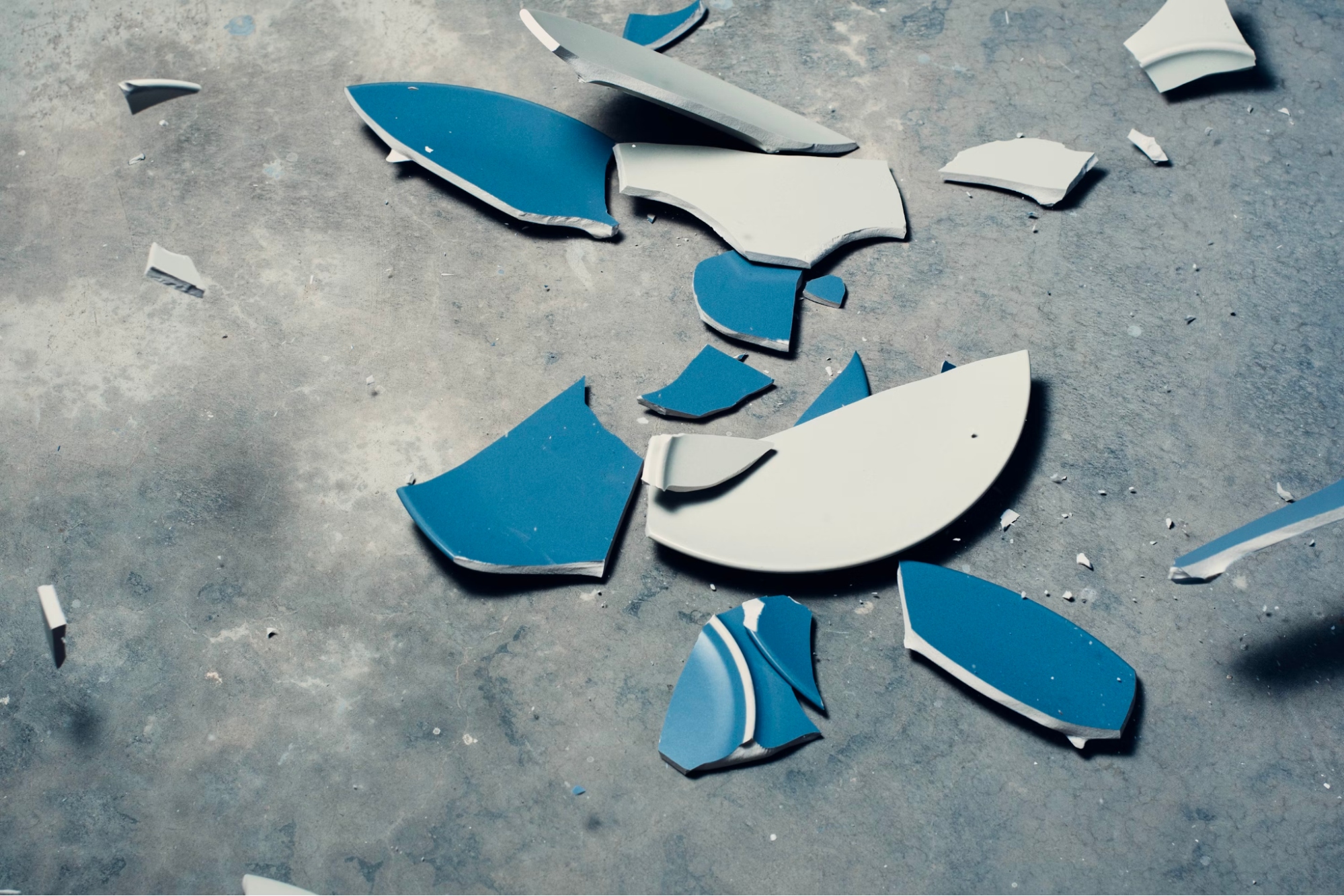 A blue ceramic plate broken into small pieces